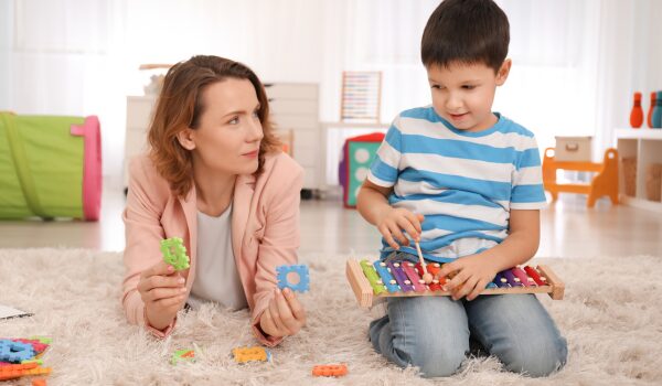 female PBS therapist working with a young boy