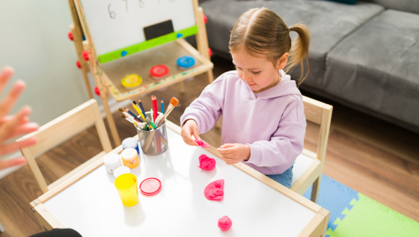 Girl playing with clay at home for occupational therapy