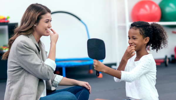 Female speech therapist helping an African American girl in therapy